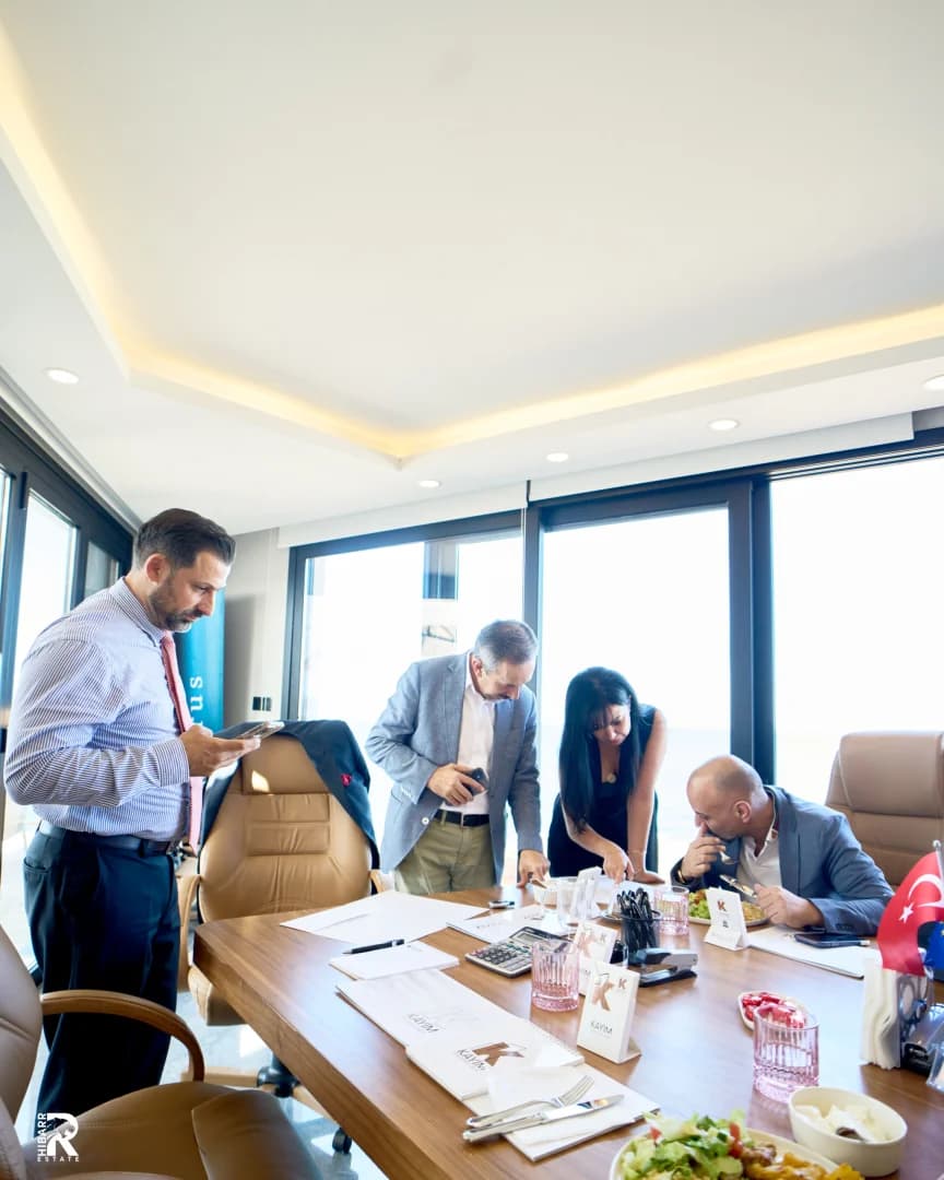 Executives reviewing and signing partnership documents in a boardroom