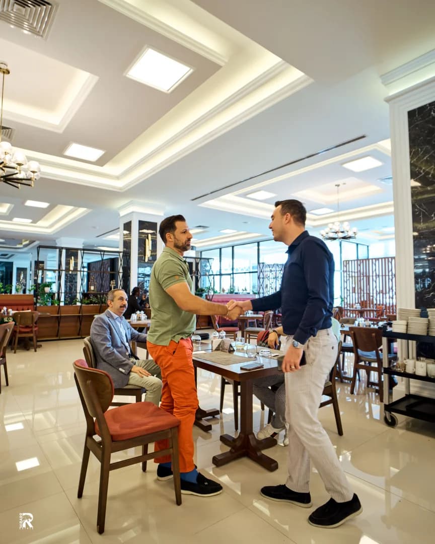 Business partners shaking hands in a modern restaurant after a meeting